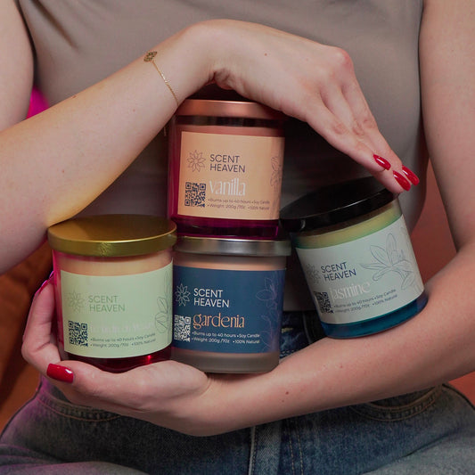 Scent Heaven candle collection held in arms — Vanilla, Gardenia, Jasmine, and Le Jardin du Mesyre.
